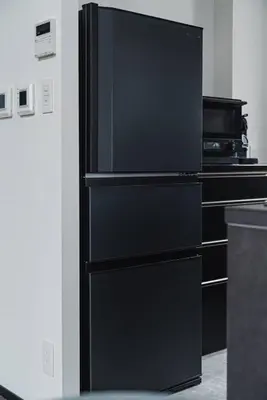 a black refrigerator freezer sitting in a kitchen at SLL Urban Suites Ebisu in Tokyo