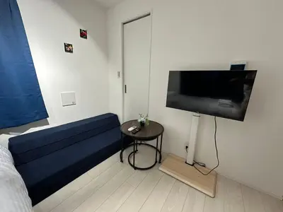 a bedroom with a bed and a flat screen tv at \u65b0\u7bc9OPEN GREW OJI residence301 in Tokyo