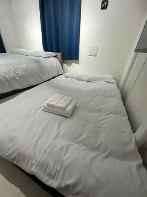 a white bed with two towels on top of it at \u65b0\u7bc9OPEN GREW OJI residence401 in Tokyo