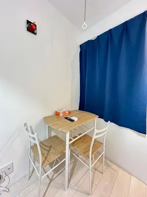 a table and chairs in a room with a blue curtain at \u65b0\u7bc9OPEN GREW OJI residence402 in Tokyo