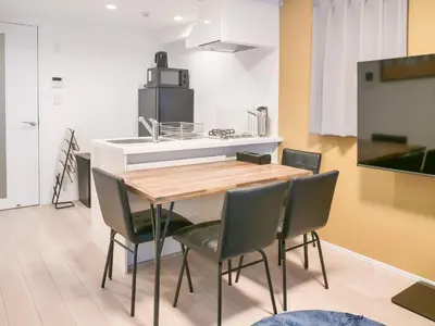 a kitchen and dining room with a wooden table and chairs at Triphome Asakusa Alpha 3min to Sensoji Temple in Tokyo