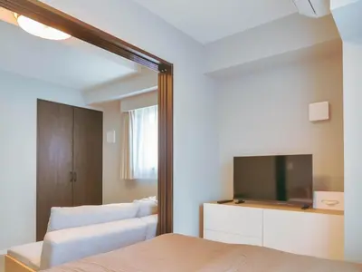 a mirror in a bedroom with a bed and a tv at Triphome Nakano 1 bedroom in Tokyo