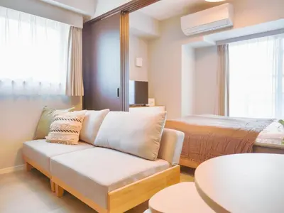 a living room with a couch and a bed at Triphome Nakano 1 bedroom in Tokyo