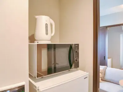 a white blender sitting on top of a microwave at Triphome Nakano 1 bedroom in Tokyo