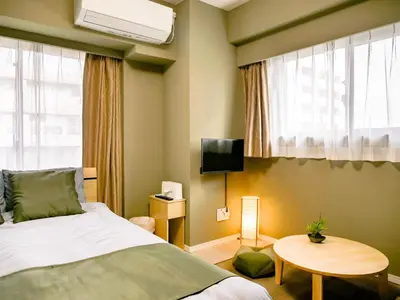 a bedroom with a bed and a tv and a table at Triphome Nakano Japanese Style in Tokyo