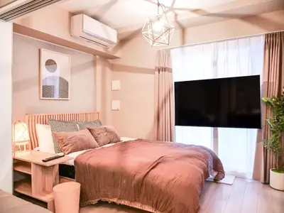 a bedroom with a large bed and a television at Triphome Asakusa 2 Bedrooms in Tokyo