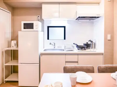 a kitchen with a white refrigerator and a table at Triphome Asakusa 2 Bedrooms in Tokyo