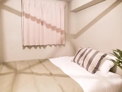 a bedroom with a bed with a pillow and a window at Triphome Asakusa 2 Bedrooms in Tokyo
