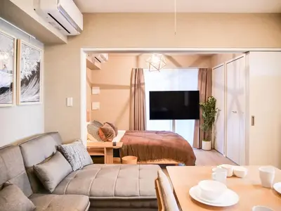 a living room with a bed and a couch at Triphome Asakusa Alpha 2 Bedrooms in Tokyo