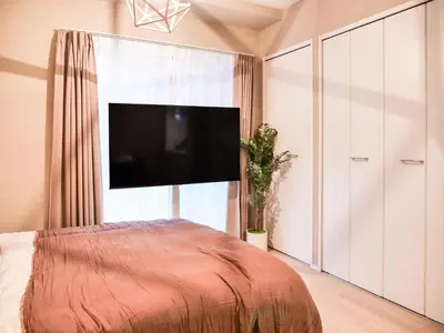 a bedroom with a bed and a flat screen tv at Triphome Asakusa Alpha 2 Bedrooms in Tokyo