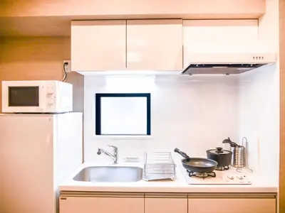 a white kitchen with a sink and a microwave at Triphome Asakusa Alpha 2 Bedrooms in Tokyo