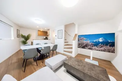a kitchen and living room with a large tv on the wall at \u7fbd\u7530\u7a7a\u6e2f8\u5206\u65b0\u7bc980\u5e73\u7c73\u6700\u59278\u540d\u4eac\u6025\u84b2\u7530 \u5f92\u6b697\u5206\u6d45\u8349\u9280\u5ea7\u30b9\u30ab\u30a4\u30c4\u30ea\u30fc\u76f4\u901a in Tokyo