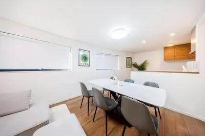 a dining room with a white table and chairs at \u7fbd\u7530\u7a7a\u6e2f8\u5206\u65b0\u7bc980\u5e73\u7c73\u6700\u59278\u540d\u4eac\u6025\u84b2\u7530 \u5f92\u6b697\u5206\u6d45\u8349\u9280\u5ea7\u30b9\u30ab\u30a4\u30c4\u30ea\u30fc\u76f4\u901a in Tokyo