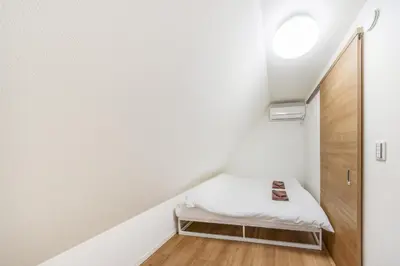 a small room with a bed in a stair case at \u7fbd\u7530\u7a7a\u6e2f8\u5206\u65b0\u7bc980\u5e73\u7c73\u6700\u59278\u540d\u4eac\u6025\u84b2\u7530 \u5f92\u6b697\u5206\u6d45\u8349\u9280\u5ea7\u30b9\u30ab\u30a4\u30c4\u30ea\u30fc\u76f4\u901a in Tokyo