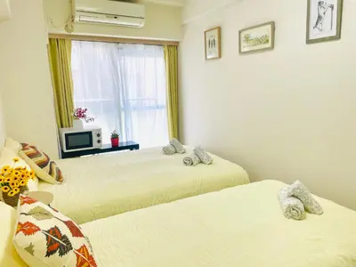 two beds in a room with a window at G25-\u65b0\u5bbf\u6700\u4e2d\u5fc3 \u6771\u65b0\u5bbf\u99c53\u5206-Shinjuku center 4 mins to ST Max 3P \u76f4\u8fbe\u65b0\u5bbf \u6e0b\u8c37 \u8868\u53c2\u9053 \u6c60\u888b \u4e0a\u91ce \u4ee3\u4ee3\u6728 \u9280\u5ea7 \u539f\u5bbf in Tokyo