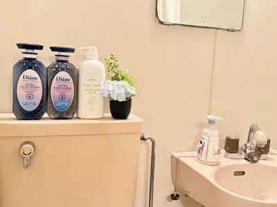 a bathroom with three bottles of soap and a sink at Ikebukuro Sugamo B01 in Tokyo