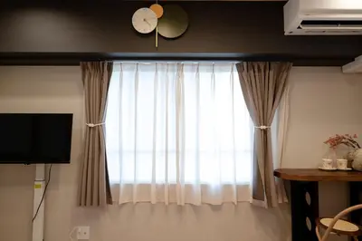 a window with curtains and a clock on a wall at Shinjuku\u65b0\u5bbf\u5546\u5708-\u6771\u65b0\u5bbf-2Room-Max5P-\u548c\u5f0f\u98ce\u683c-\u4e0a\u91ce\u65b0\u5bbf\u6c60\u888b\u6e0b\u8c37\u76f4\u8fbe in Tokyo
