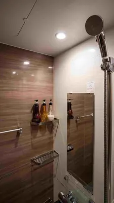 a bathroom with a shower and a sink with a mirror at \u904a\u96f2\u4eadYuuntei in Tokyo
