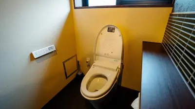 a bathroom with a toilet in a yellow room at \u904a\u96f2\u4eadYuuntei in Tokyo