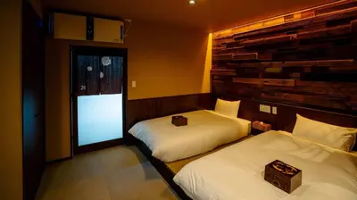 two beds in a hotel room with a window at \u904a\u96f2\u4eadYuuntei in Tokyo