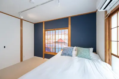 a bedroom with a bed with blue walls and windows at Tokyo Akabane 2BR MAX5, Ikebukuro Shinjuku Ueno Ginza in Tokyo
