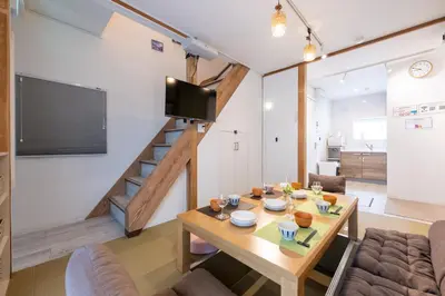a living room with a wooden table and a staircase at Tokyo Akabane 2BR MAX5, Ikebukuro Shinjuku Ueno Ginza in Tokyo