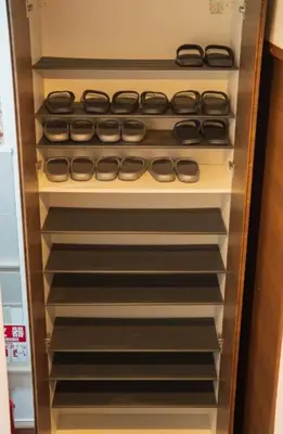 an empty refrigerator with its door open with black dishes at \u6c60\u888b\u6238\u5efa in Tokyo