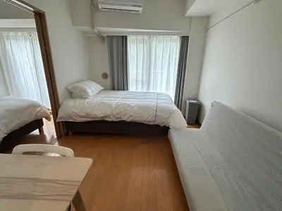 a small room with two beds and a couch at Sunshine Grand Hotel Ikebukuro in Tokyo