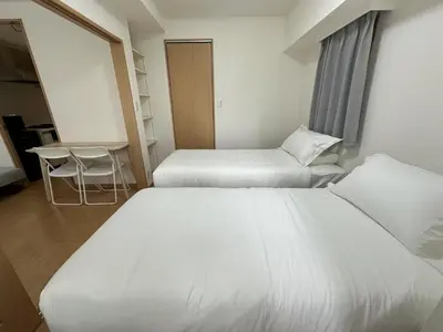 a hotel room with two beds and a table at Sunshine Grand Hotel Ikebukuro in Tokyo