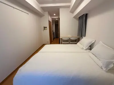 a hotel room with two beds and a table at Sunshine Grand Hotel Ikebukuro in Tokyo