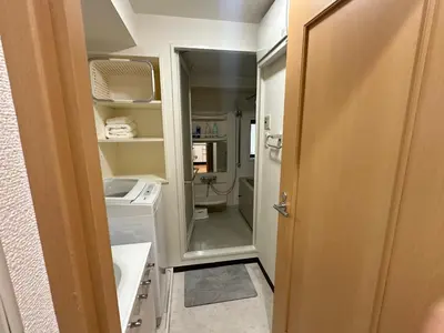 a small bathroom with a washer and dryer in it at Sunshine Grand Hotel Ikebukuro in Tokyo