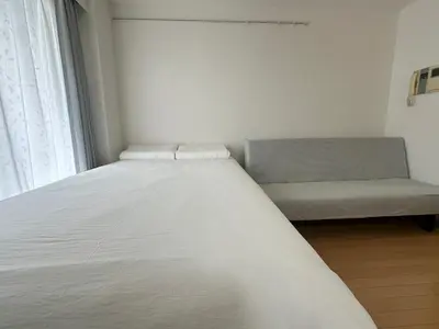 a white bed and a couch in a room at Sunshine Grand Hotel Ikebukuro in Tokyo