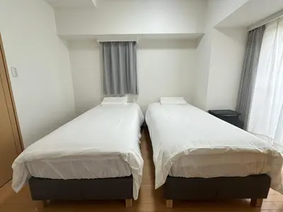 two beds in a room with white sheets at Sunshine Grand Hotel Ikebukuro in Tokyo