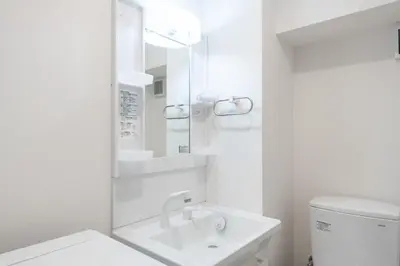 a white bathroom with a sink and a mirror at GLiCION\u738b\u5b50 in Tokyo