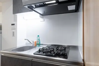 a kitchen with a stove top oven next to a sink at GLiCION\u738b\u5b50 in Tokyo