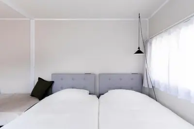 two beds in a small bedroom with a window at T4U Shinjyuku Okubo in Tokyo