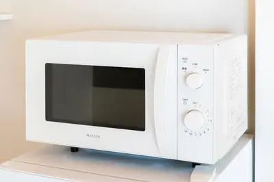 a white microwave oven sitting on top of a shelf at Ueno-an 4,5F in Tokyo