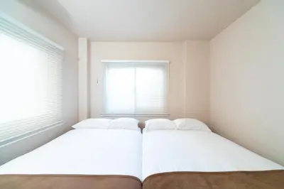 two beds in a room with two windows at Ueno-an 4,5F in Tokyo