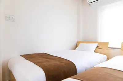 a bedroom with two beds and a window at Ueno-an 4,5F in Tokyo