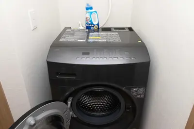 a computer and a washing machine in a room at Kutsurogi Sumida House \u304f\u3064\u308d\u304e\u30b9\u30df\u30c0\u30cf\u30a6\u30b9 in Tokyo