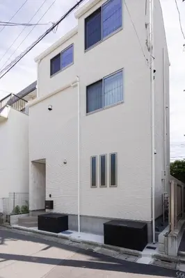 a white building with blue windows on a street at Kutsurogi Sumida House \u304f\u3064\u308d\u304e\u30b9\u30df\u30c0\u30cf\u30a6\u30b9 in Tokyo