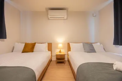 two beds sitting next to each other in a room at Kutsurogi Sumida House \u304f\u3064\u308d\u304e\u30b9\u30df\u30c0\u30cf\u30a6\u30b9 in Tokyo