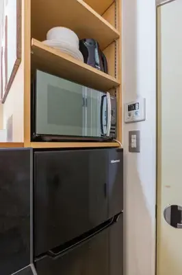 a microwave on top of a refrigerator in a kitchen at Budget Private StayIkebukuro Anime Area Sleeps 7 in Tokyo