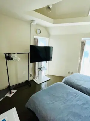 a bedroom with two beds and a flat screen tv at Budget Private StayIkebukuro Anime Area Sleeps 7 in Tokyo