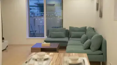 a living room with a green couch and a table at Friendly In Shinjuku \u30d5\u30ec\u30f3\u30c9\u30ea\u30fc\u30a4\u30f3\u65b0\u5bbf in Tokyo