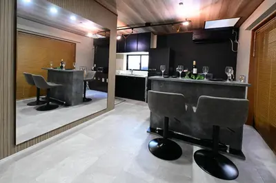 a bar with chairs and a counter in a room at Rakuna Inn \u5bdb sasazuka3 in Tokyo