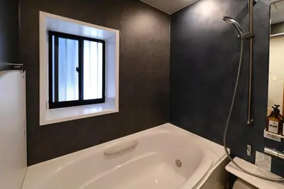 a bathroom with a white tub and a window at Rakuna Inn \u5bdb sasazuka3 in Tokyo