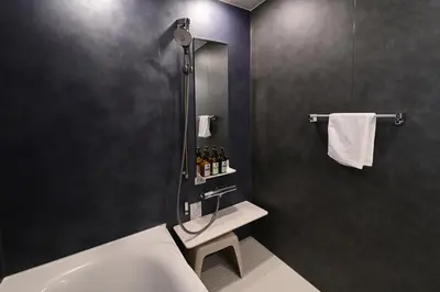 a bathroom with a shower and a toilet and a sink at Rakuna Inn \u5bdb sasazuka3 in Tokyo