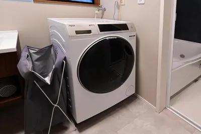 a white washing machine sitting in a room at Rakuna Inn \u5bdb sasazuka3 in Tokyo