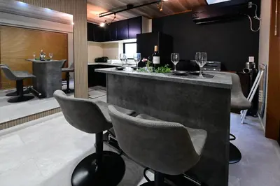 a bar with chairs and wine glasses in a room at Rakuna Inn \u5bdb sasazuka3 in Tokyo